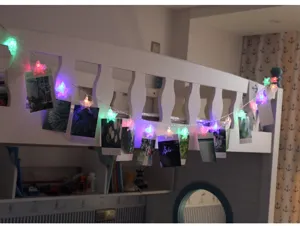 Vue détaillée des pinces à photos LED en forme d'étoile sur un cadre de lit