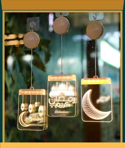 Primer plano de tres luces LED colgantes para el Ramadán con motivos de luna y mezquita.