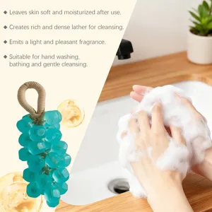 Vista detallada del jabón en forma de uva verde azulado con espuma rica y cuerda para colgar