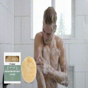 Hombre usa el jabón exfoliante de luffa OCEAURA en la ducha para una piel suave
