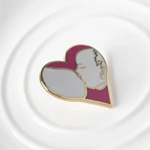 Detailed macro view of a pink heart-shaped enamel pin with breastfeeding illustration design