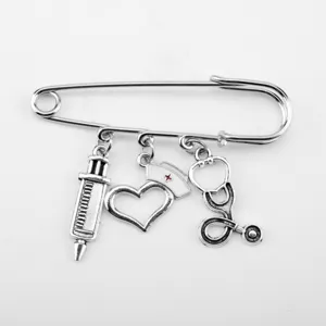 Detailed view of silver medical brooch with syringe, nurse hat, and stethoscope charms