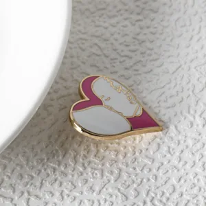 Close-up of a pink heart-shaped breastfeeding mother enamel pin for Mother's Day