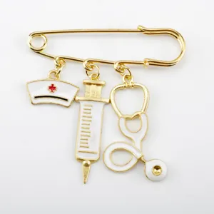 Detailed close-up of a gold-toned medical brooch with syringe and nurse hat charms