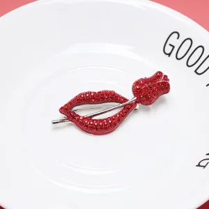 Detail view of red lips rose brooch featuring sparkling red rhinestones on white plate
