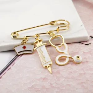Close-up detail of creative medical-themed safety pin brooch with nurse hat and syringe charms