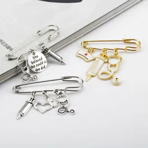 Detail of silver and gold nurse-themed brooches with syringe and stethoscope charms.