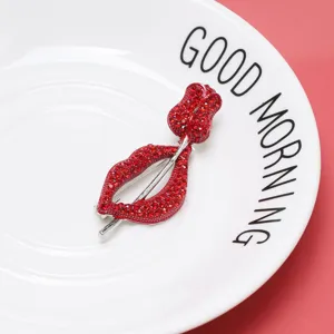 Close-up of elegant red lip and rose brooch featuring sparkling red rhinestones.