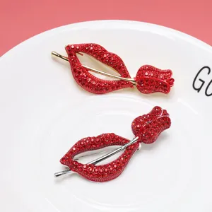Detailed macro view of red rhinestone encrusted lip and rose brooches on a white plate