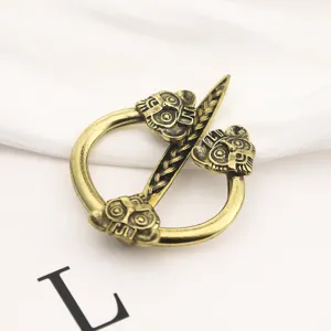 Dettaglio di una spilla per mantello vichinga in bronzo vintage con teste ornate