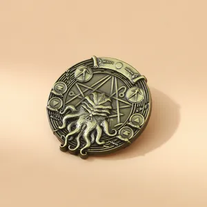 Close-up of vintage bronze Cthulhu Necronomicon metal badge pin with intricate carvings