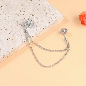 Detailed view of silver heart lock and key brooch with double chains and rhinestones.