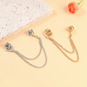 Detailed view of heart and rose chain brooches in gold and silver for elegant suits.