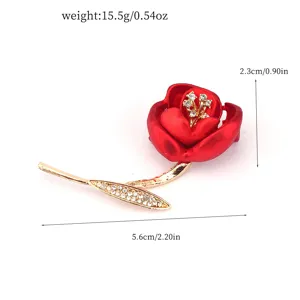 Detailed view of an elegant red rose brooch featuring rhinestone accents and gold stem
