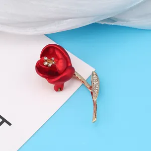 Detailed view of an elegant red rose brooch with sparkling rhinestones and gold stem