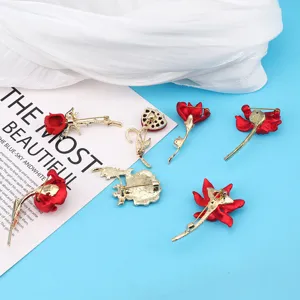 Detailed back view of multiple red rose flower brooches showing gold-tone pins and finish