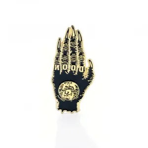 Macro view of black and gold monster claw enamel brooch with DOOM metal engraving