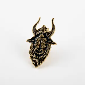 Detail view of a black and gold demon goat enamel pin for Halloween costume accessories.