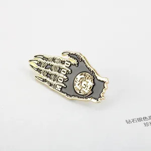 Close-up of black and gold enamel doom claw pin with intricate engraved details for Halloween