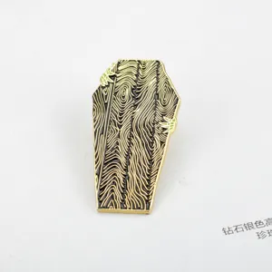 Macro view of coffin-shaped enamel brooch with wood grain and green claw details