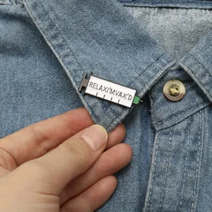 Vue rapprochée d'un pin's seringue médicale en émail sur un col de chemise en jean