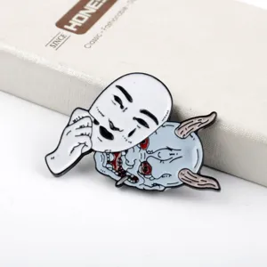 Close-up detail of Hannya enamel pin showing white mask lifting to reveal demon face