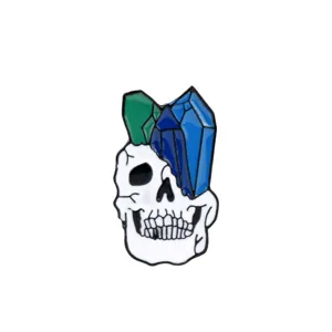 Detaillierte Nahaufnahme einer Emaille-Totenkopf-Brosche mit blauen und grünen Kristallen