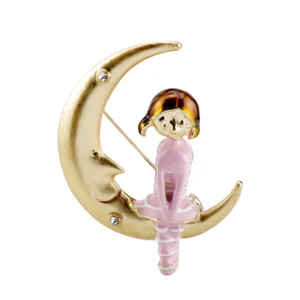 Detail view of a cartoon girl sitting on a gold moon brooch with pink enamel