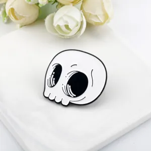 Nahaufnahme der niedlichen Cartoon Totenkopf Emaille Pin in Schwarz und Weiß für Halloween