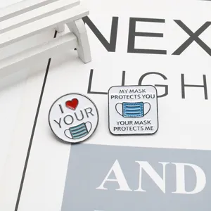 Détail de deux épinglettes en émail avec sensibilisation aux masques et slogans médicaux