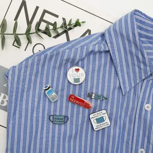 Gros plan de pin's en émail médicaux avec seringue et masque sur une chemise à rayures.