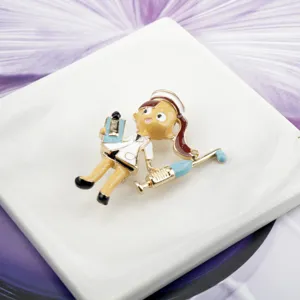 Close-up of a cartoon nurse brooch with syringe and clipboard detail in enamel finish.
