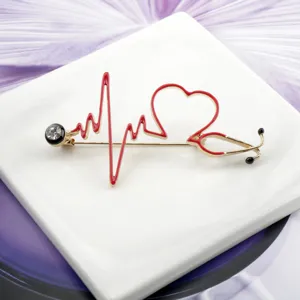 Detailed view of heart-shaped stethoscope brooch with red enamel and crystal for medical staff