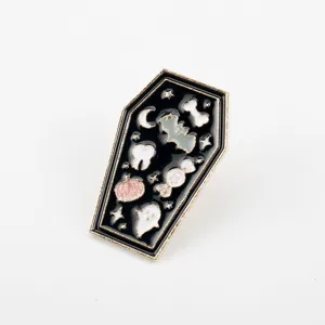 Detailed macro view of the Halloween coffin enamel pin with ghost and pumpkin motifs