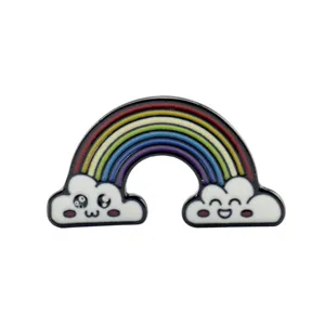 Dettaglio di una colorata spilla arcobaleno in smalto con graziose nuvole sorridenti dei cartoni