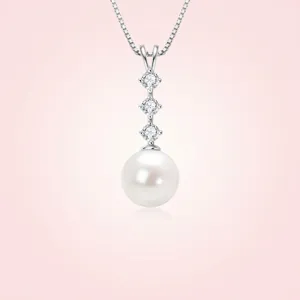 Detailed macro view of a round white freshwater pearl pendant with three clear stones