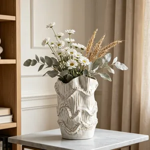 Close-up of artistic ceramic vase with wavy texture and rustic cream glaze finish