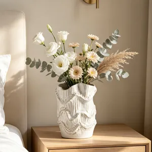 Detailed view of a vintage white ceramic vase with artistic wavy texture and flowers.