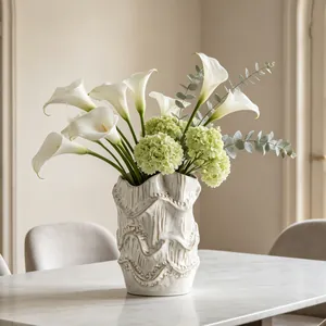 Artistic textured white ceramic vase with elegant calla lilies and hydrangea decor