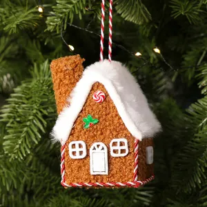 Detailed view of a plush gingerbread house ornament featuring soft white snowy roof texture