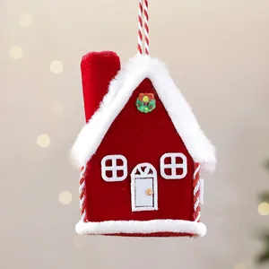 Detail of a red plush house Christmas ornament with white faux fur and a hanging cord.