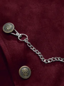 Detail of burgundy velvet waistcoat with heraldic buttons and silver chain.