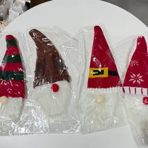 Vista detallada de cuatro fundas de punto para botellas de vino con gnomos de Navidad