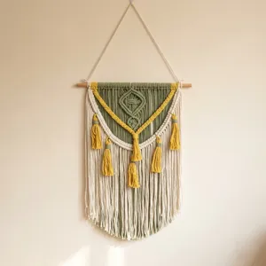Détail de cette tenture murale en macramé tissé à la main avec des glands vert et jaune