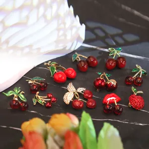 Vue détaillée de broches cerises créatives avec détails en émail et strass brillants