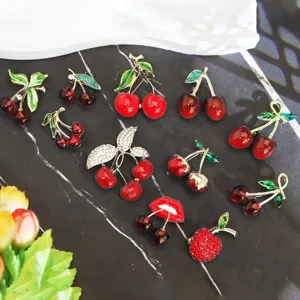 Variété de broches créatives en forme de cerise avec cristaux étincelants et émail rouge vif.
