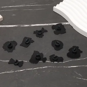 Gros plan des fermoirs noirs en forme de papillon pour broches créatives en émail