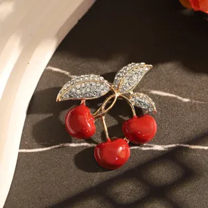Vue rapprochée d'une broche cerise élégante avec fruits rouges et feuilles en strass brillants