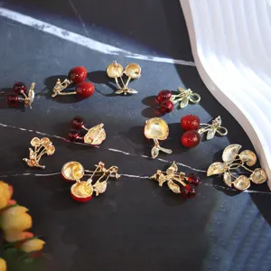 Vue détaillée de broches cerises rouges à la moda avec attaches dorées