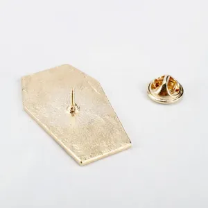Detailed macro view of the gold-toned coffin brooch back with a secure butterfly clutch